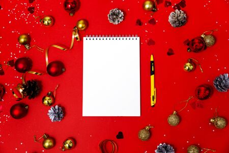 Notepad for text on the Christmas red table.の写真素材