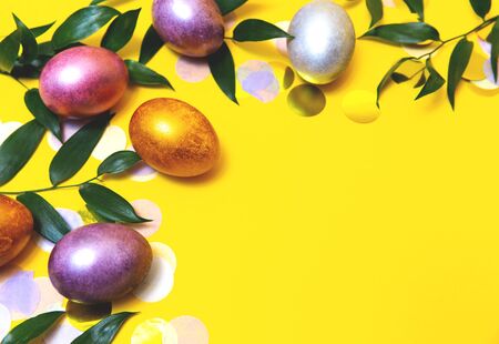 Lots of Easter eggs on a yellow background and confetti.の写真素材