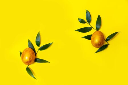 Two Golden Easter eggs on a yellow background.の写真素材