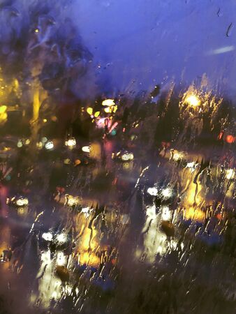 Lights of a big city at night through a rainy glass. Background. Multicolor.の写真素材