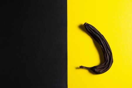 Dried banana on a black black paper background. View from above. Flat lay. Design concept for beauticians. Dry skin of a banana like a wrinkled face of a person.の写真素材