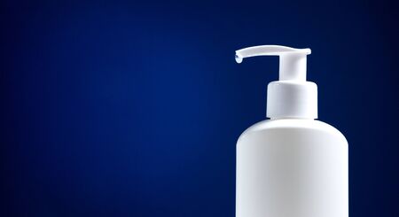White sanitizer bottle on a dark blue background. Virus design concept. Minimalism.の写真素材