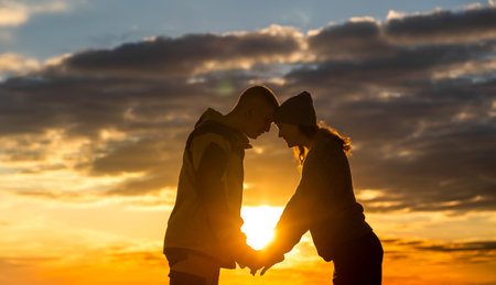 A young man and his girlfriend in the Park drink tea. They sit under a tree, watching the sunset....
