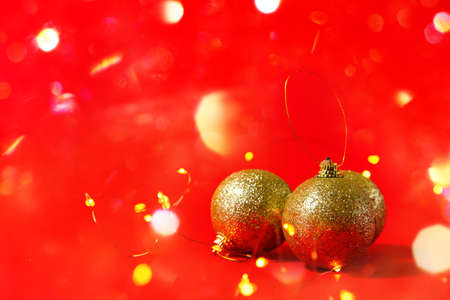 Abstract Christmas background on red. Christmas Golden balls and bright sparkles.の写真素材