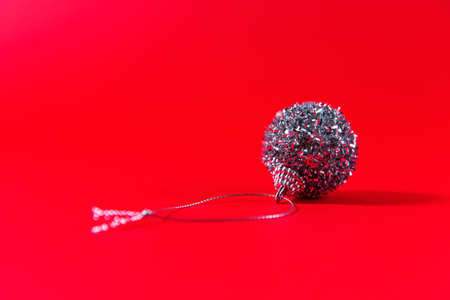 Subject of a Christmas decoration on a red solid background. New year's ball. Minimalism pattern. Copyspace.の写真素材