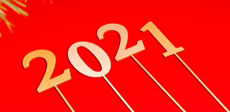 New year or Christmas banner on a red background. Wooden numbers 2021 on the red table. The concept 2021.の写真素材