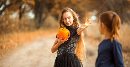 Two teenage girls prepare orange pumpkins for Halloween.の写真素材