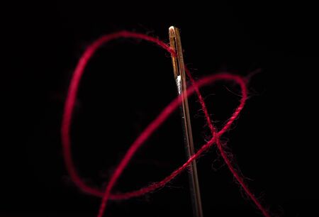 needle and thread on a black backgroundの写真素材