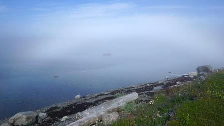 A boat in the northern bay on a foggy morning.の写真素材