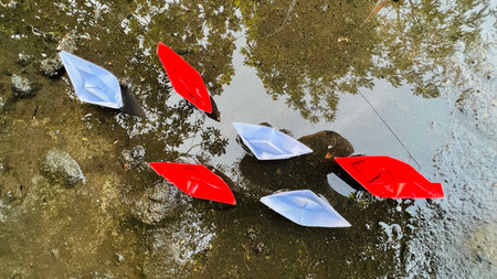 Paper boat Red and white floating on the water.の写真素材