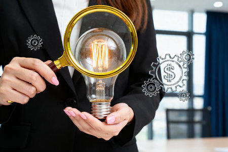 A businesswoman in a black suit holds a lightbulb under a magnifying glass, symbolizing innovation and ideas. Gears and dollar signs are also present.の素材