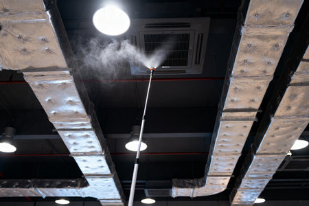 A worker is sanitizing the air ducts in a building to help improve air quality and remove contaminantsの写真素材