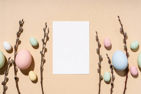 A festive arrangement of pastel Easter eggs and delicate pussy willow branches frames a blank white...