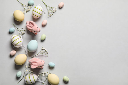 A charming arrangement of decorative Easter eggs and plush bunny figures scattered with delicate...