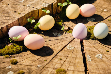 Pastel colored Easter eggs are scattered across a weathered wooden tree stump, surrounded by vibrant...