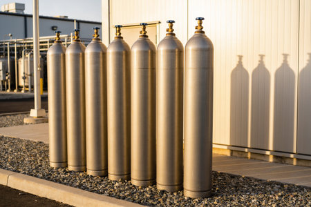 A row of metal gas cylinders on the background of a white wall