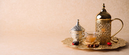 Golden Islamic tea set with ornate details, served on a neutral background. Spiritual and cultural...