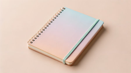 Notebook features a spiral binding and pastel gradient cover, resting on a smooth surface, ideal for creative writing and artistic endeavorsの写真素材