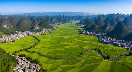 Stunning aerial perspective of vibrant rice terraces and a flowing river, framed by towering mountains, highlighting the harmony between nature and agricultureの写真素材