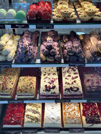 Assorted pastries and desserts are beautifully arranged in a bakery display, showcasing vibrant...