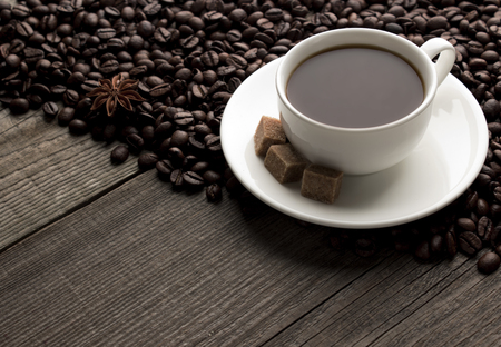 Cup of cofee  with sugar and cofee beans on the tableの写真素材