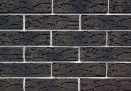 Dark brown brick wall with white cement background.の写真素材