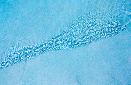 Water ripples on blue tiled swimming pool backgroundの写真素材