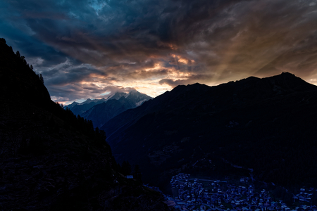 Cloudy sunrise from Pension Edelweiss with Sun light breaking over mountains above Zermatt, Switzerlandの写真素材