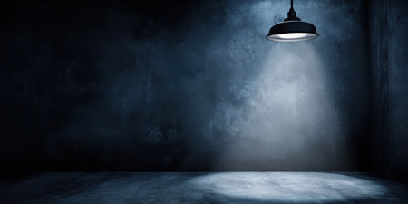 A dimly lit room features a single overhead spotlight casting light on the cold gray floor.の素材