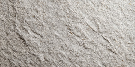 Close view of a handmade paper surface featuring a unique texture. Soft natural light enhances the details of the fibers and creases, showcasing its artisanal quality.の素材