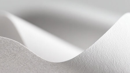 White textured paper gently curls along its edge, showcasing smooth lines and subtle shadows. This close-up highlights the pristine quality of the paper surface.の素材