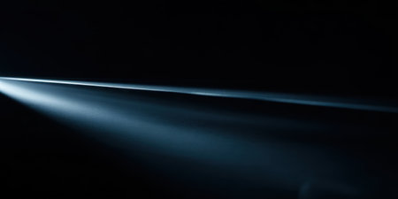 Bright light beams cut through the darkness, creating a striking contrast. The focused rays illuminate the surroundings in an artistic manner.の素材