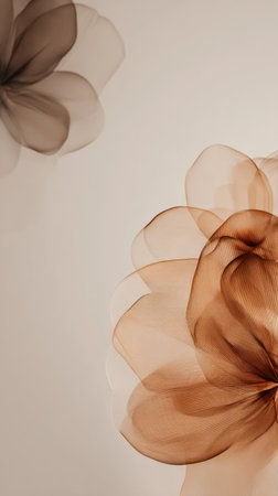 Delicate flowers made of sheer fabric in soft brown tones are placed against a light background, creating a warm, inviting atmosphere for decor.の素材