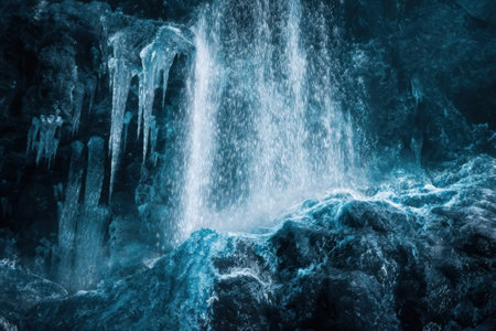 Water flows down from a glacier, creating a beautiful waterfall effect against the backdrop of icy blue rocks and frigid air, capturing nature's winter beauty.の素材