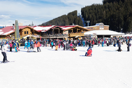 Bansko, Bulgaria, January 27, 2016:  Bansko ski station, cable car lift and people waiting in line near it in Bansko, Bulgaria. Snow mountain peaks and blue sky at the backgroundのeditorial素材