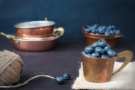 Blueberries dark picture. Fresh fruits, berries in an old copper cup. Dark Styled Stock Photo, Black Backgroundの写真素材