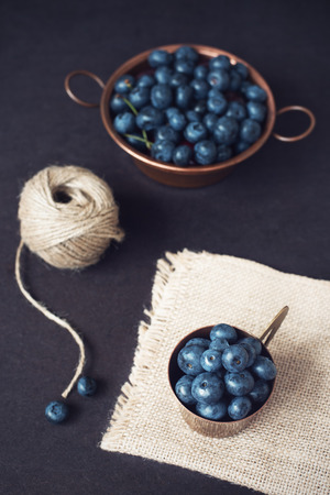 Blueberries dark picture. Fresh fruits, berries in an old copper cup. Dark Styled Stock Photo, Black Backgroundの写真素材