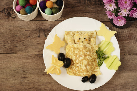 Creative idea for kids snack, breakfast or lunch. Sleeping bear from bulgur, rice and quinoa under the blanket of egg omelet. Flowers and butterflies with cucumber, sandwiches of cheese and bread. Fun and healthy kids meal. Art of foodの写真素材