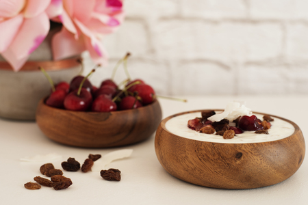 Oat Flakes With Yogurt And Fruits. Cherries, Raisins And Coconut Chips. Overnight Breakfast. Healthy Food Concept. Fitness Mood Diet. Summer Light Snack. Bright Brick Wall Background.の写真素材