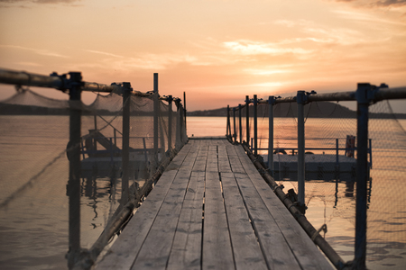 Wooden bridge on the beach and beautiful sunset near the seaの写真素材