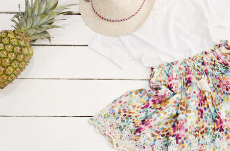 Straw hat, floral dress, pineapple. White Old Wooden Background.の写真素材