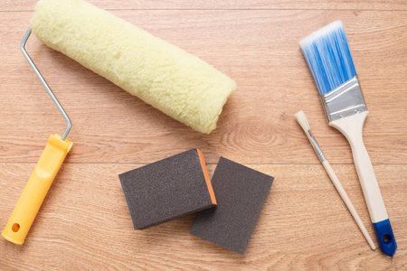 Painting brushes and rollers on wooden background. Building tools for painting surfaces