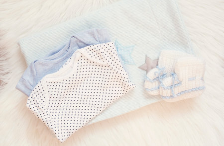 Blue Blanket, Bodysuits, Knitted baby Boots And Bunny Toy On A White Fur Carpet. Baby Mockup....