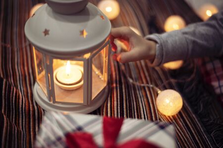 Merry Christmas and Happy Holidays!  Xmas winter holidays concept. Child girl hand holding a candlestick. Christmas decoration, festive lightsの写真素材