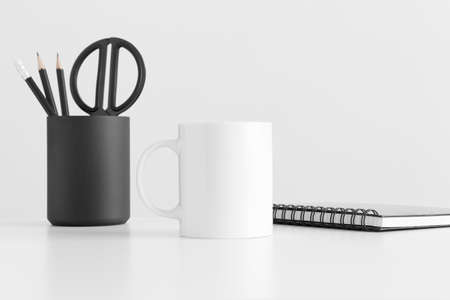 Mug mockup with workspace accessories on a white table.の写真素材