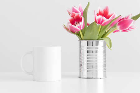 Mug mockup with pink tulips in a pot on a white table.の写真素材