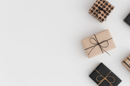 Black and kraft christmas gifts on a white table. Flat lay with blank copy space.