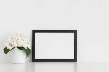 Black frame mockup with a hortensia in a pot on a white table.Landscape orientation.の写真素材