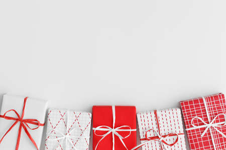 Red and white christmas gifts on a white table. Flat lay with blank copy space.の写真素材
