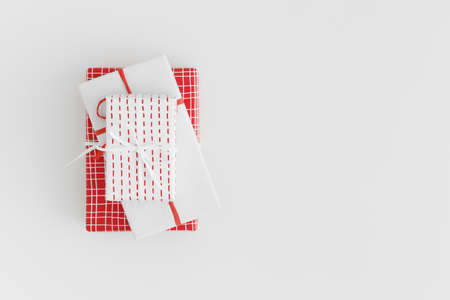 Red and white christmas gifts on a white table. Flat lay with blank copy space.の写真素材